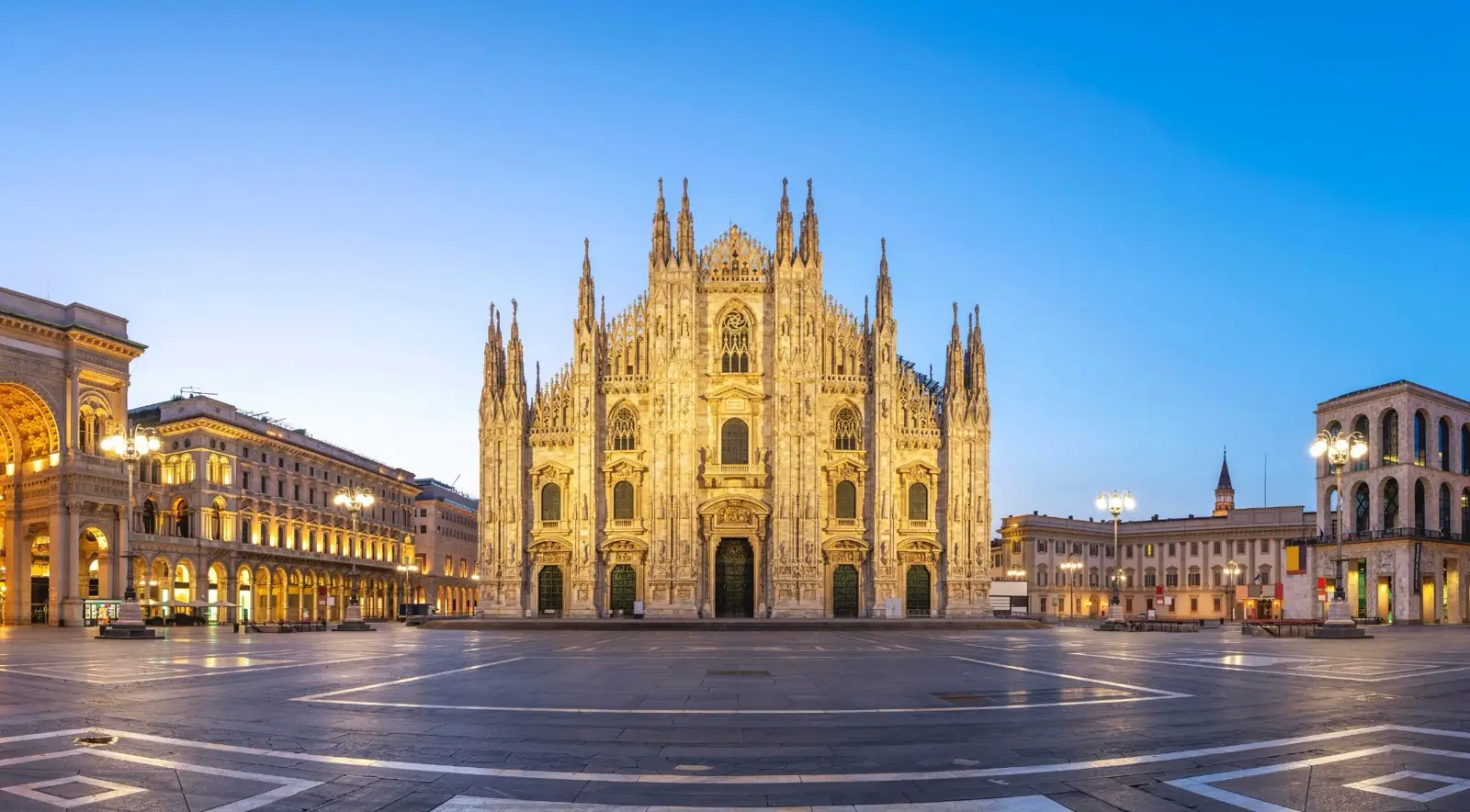 Milan Duomo rooftop terrace with marble spires and statues above Piazza del Duomo